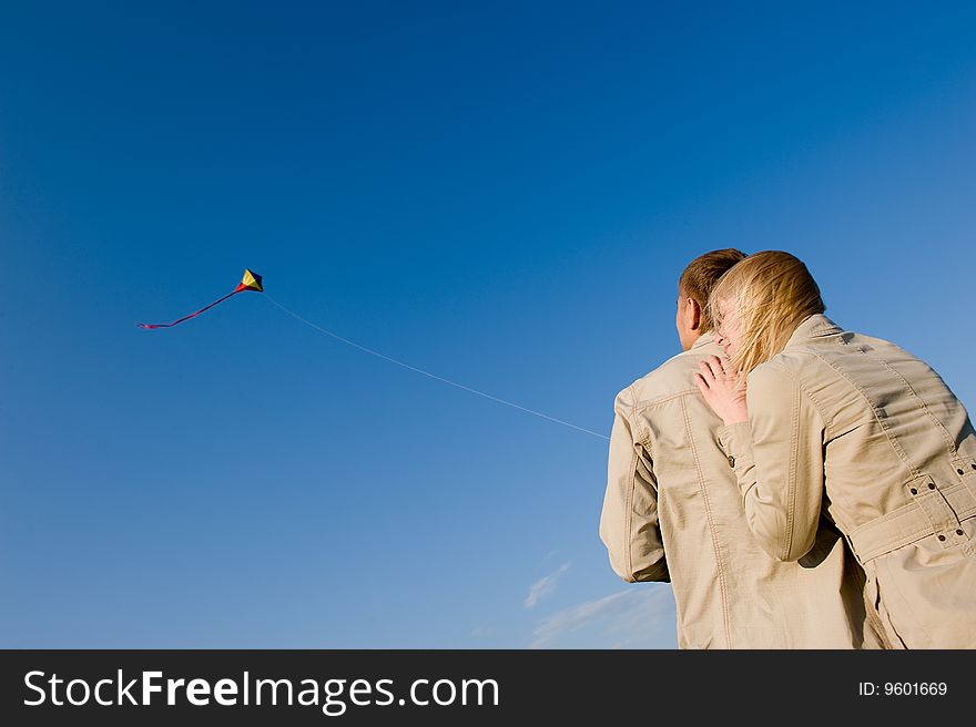 Happy young couple in love flying a kite