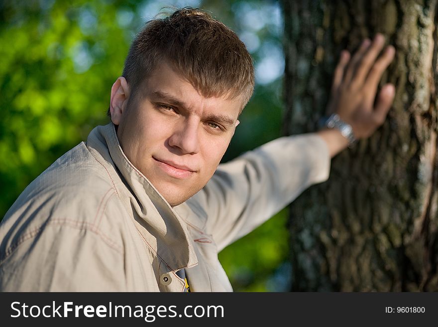 Close-up portrait of young man holding from a tree. Close-up portrait of young man holding from a tree