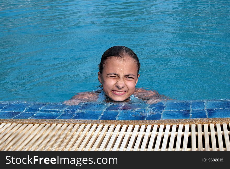Beautiful girl in pool with blue water