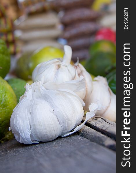 Garlic for sale in market,limes in background. Garlic for sale in market,limes in background