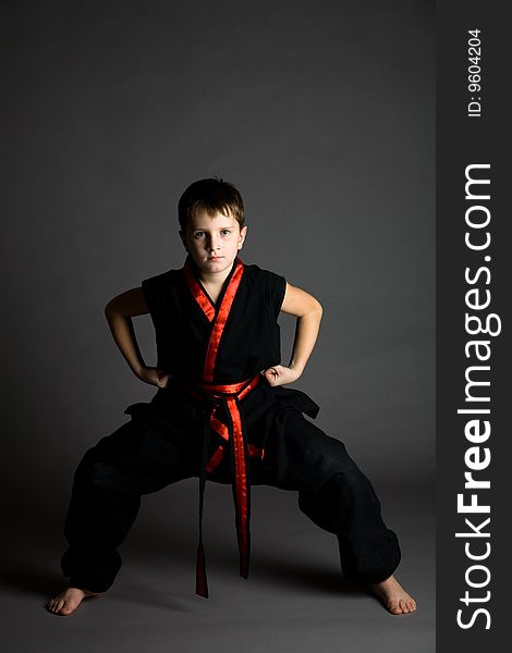 Boy in a black kimono on a grey background