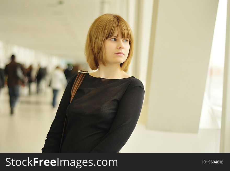 The nice girl looks in a window in shopping centre