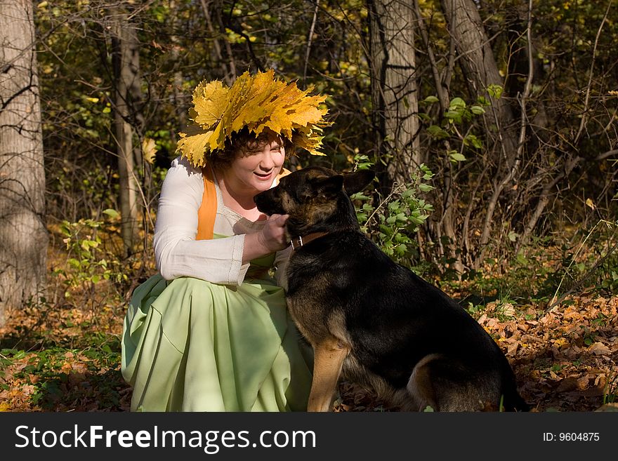 Woman and dog in autumn forest