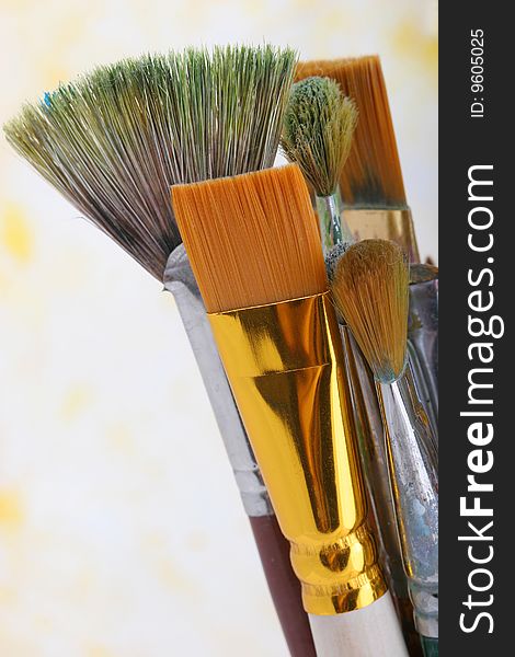 Old paintbrushes on painted background.