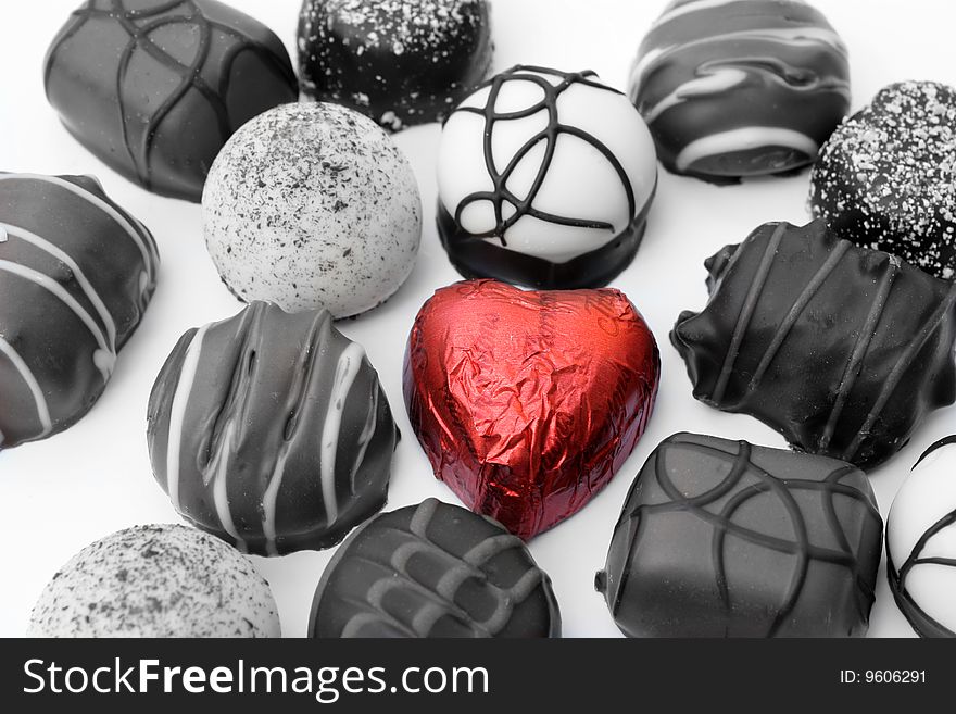 A selection of quality chocolates with a red heart highlighted to show love. A selection of quality chocolates with a red heart highlighted to show love