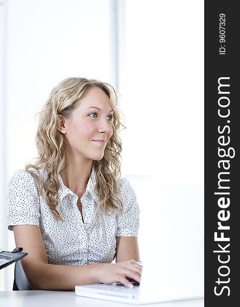 Young business woman in office with laptop