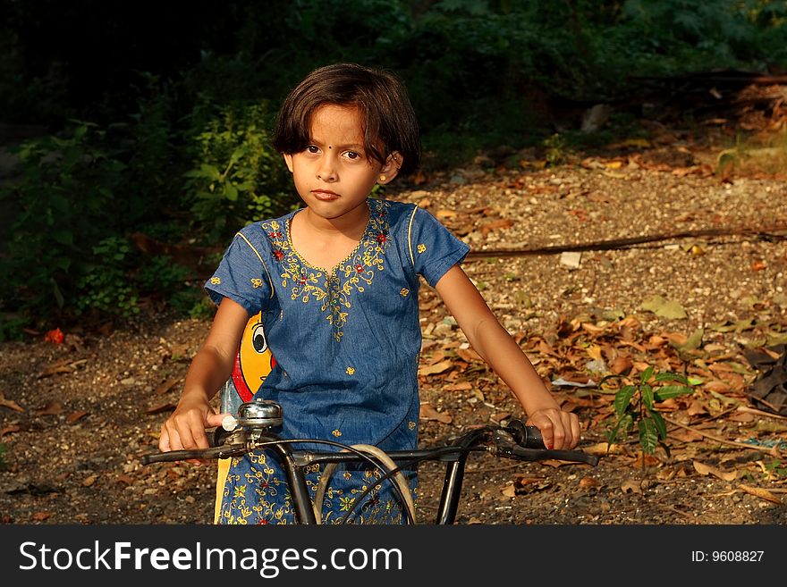 A small girl seated on her little and small bicycle. A small girl seated on her little and small bicycle.