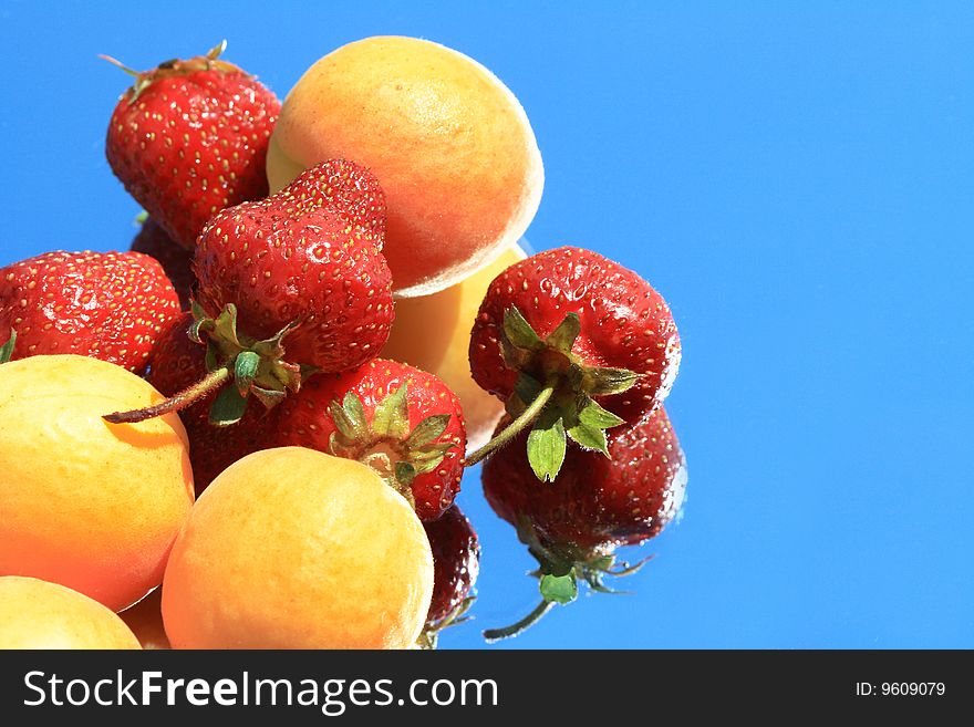 Strawberries and apricots isolated on blue background. Strawberries and apricots isolated on blue background