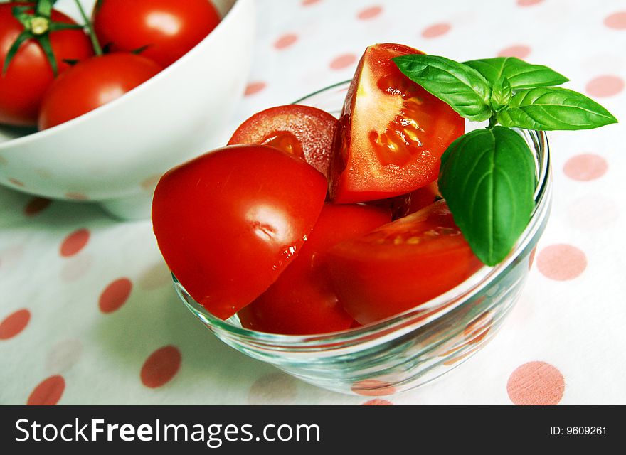 A glass jar with tomatoes and basil sprig, closeup. A glass jar with tomatoes and basil sprig, closeup