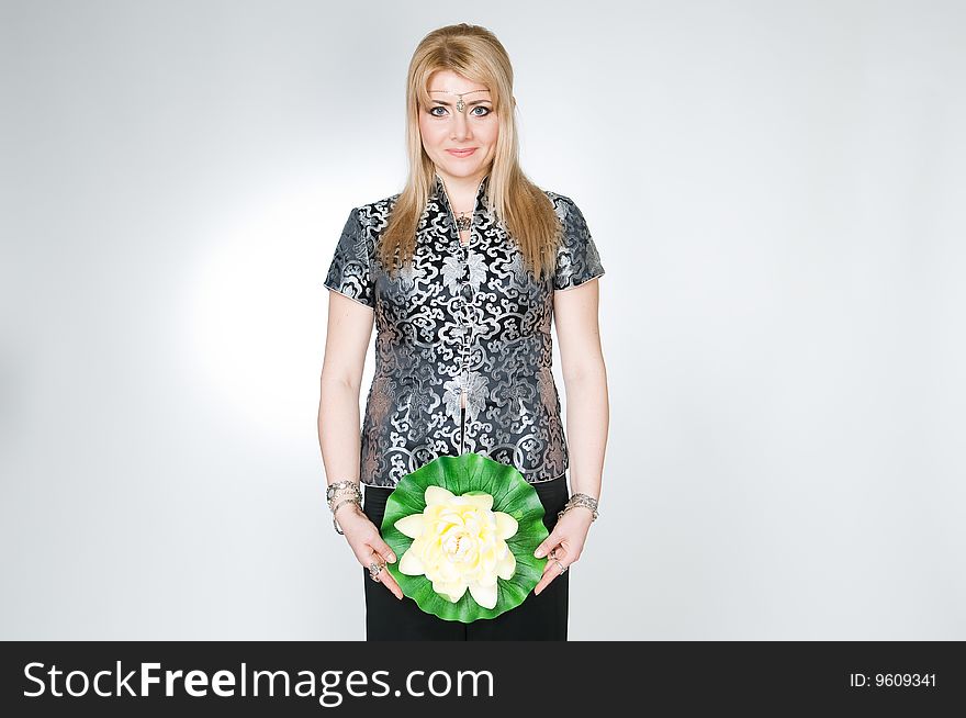 Attractive woman with lotus flower, studio shot