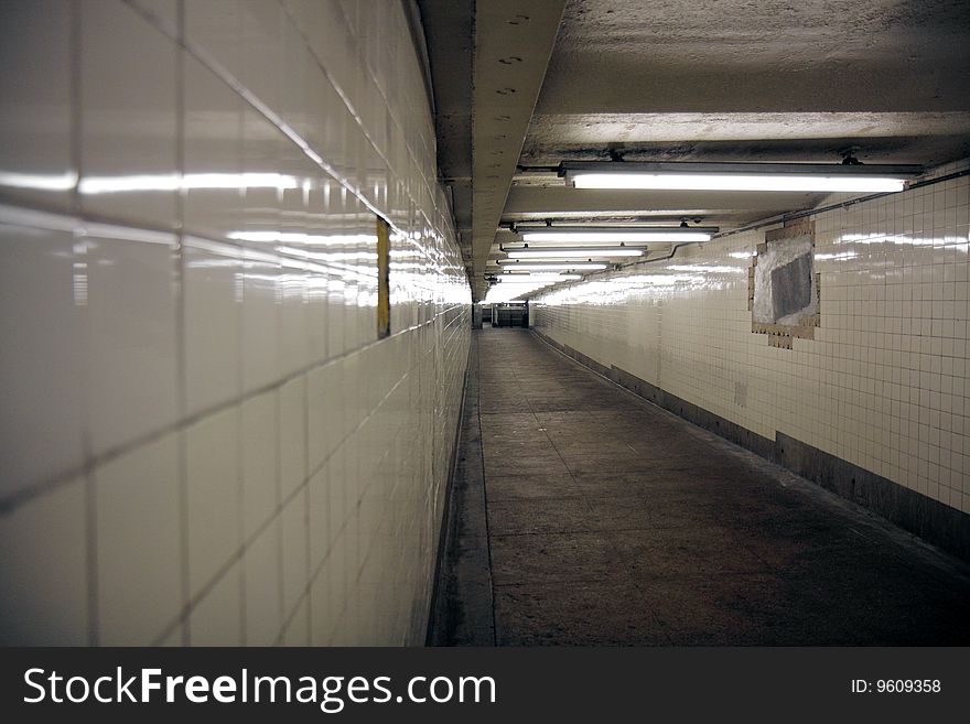 A tiled subway walkway at a Brooklyn subway station, shot with shallow depth of field. A tiled subway walkway at a Brooklyn subway station, shot with shallow depth of field