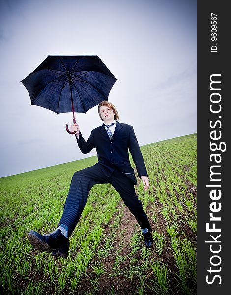 Businessman with umbrella outside, wide angle view