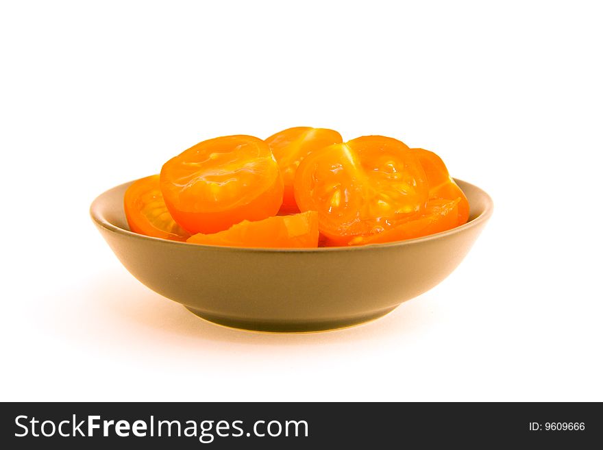 Chopped small red tomatoes in a black bowl on a white background. Chopped small red tomatoes in a black bowl on a white background