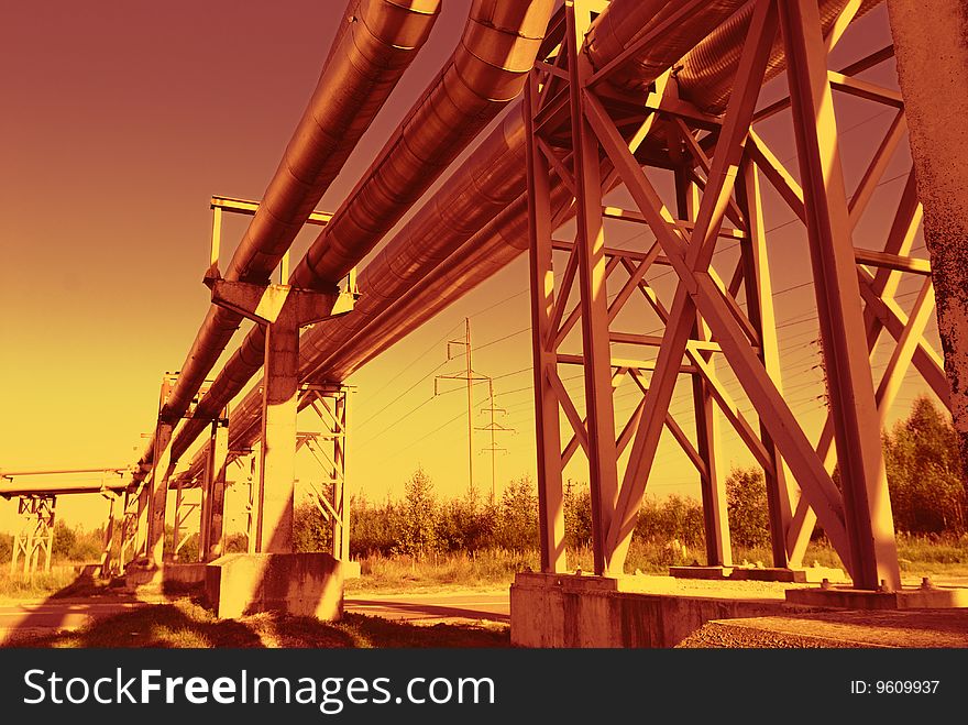 Industrial pipelines on pipe-bridge against blue sky. Industrial pipelines on pipe-bridge against blue sky.