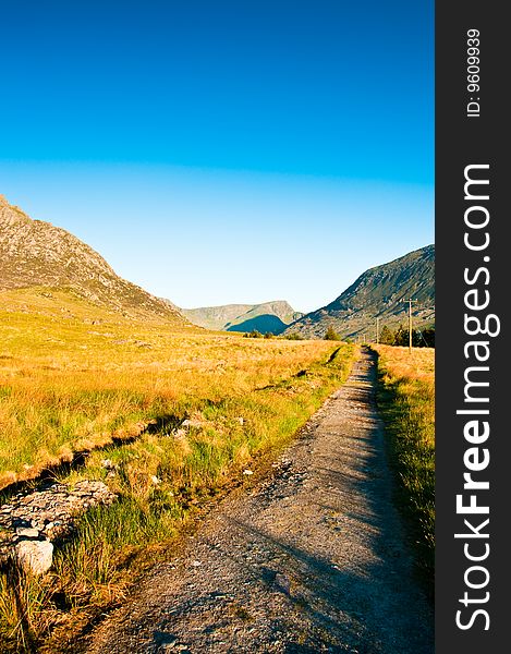 Path in Wales with  green fields and blue sky next to Tryfan. Path in Wales with  green fields and blue sky next to Tryfan