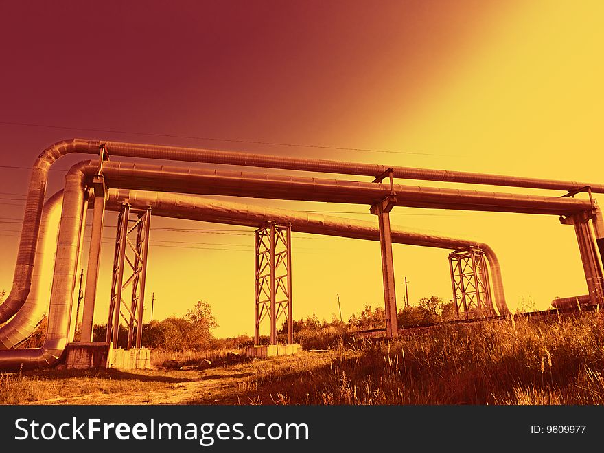 Industrial pipelines on pipe-bridge against blue sky. Industrial pipelines on pipe-bridge against blue sky.