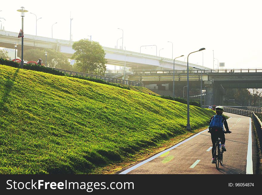 A man cycling along a cycling lane in a city. A man cycling along a cycling lane in a city.