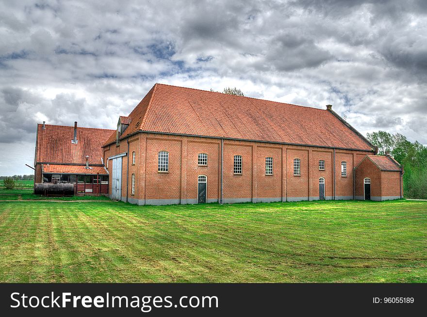 Brick farmhouse or barn in green rural field. Brick farmhouse or barn in green rural field.