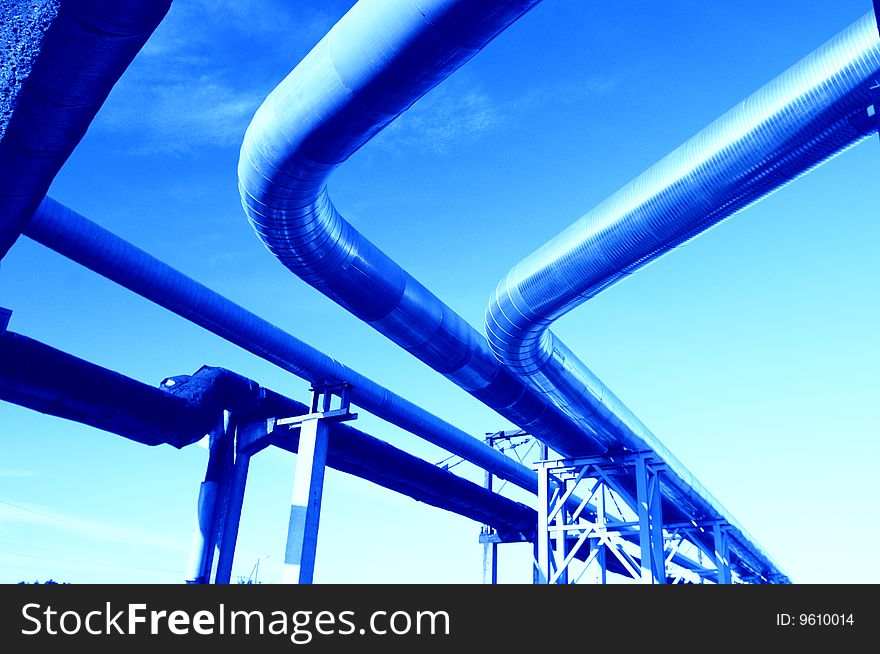 Industrial pipelines on pipe-bridge against blue sky. Industrial pipelines on pipe-bridge against blue sky.