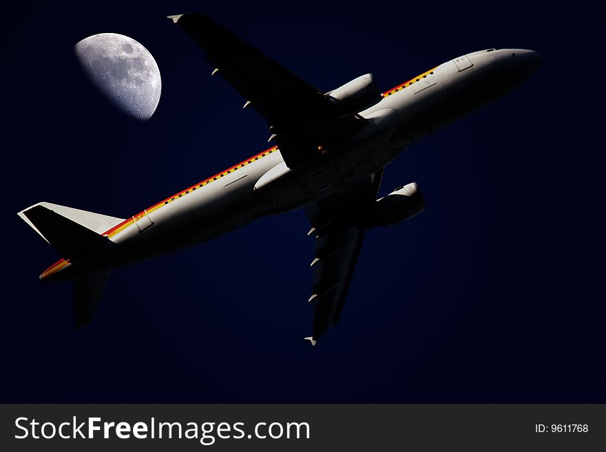 An airplane flying in the night under moonligth