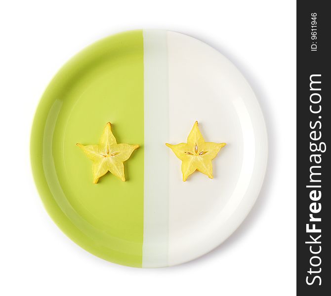 Two slices of starfruit (carambola) on a two-colored plate. Two slices of starfruit (carambola) on a two-colored plate