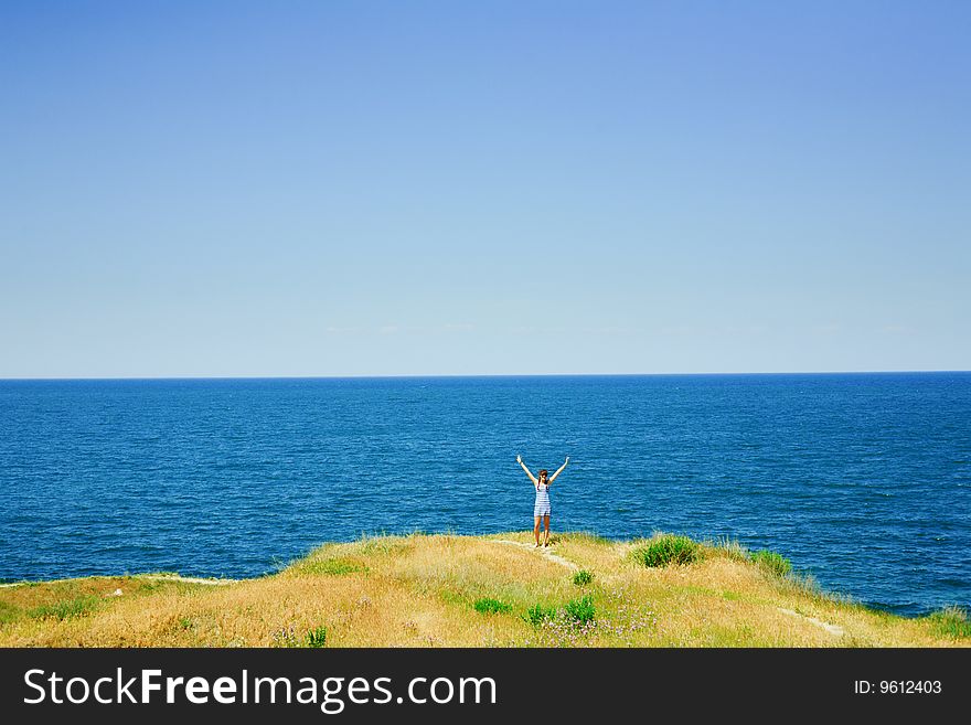 Girl standing against the blue sea. Girl standing against the blue sea