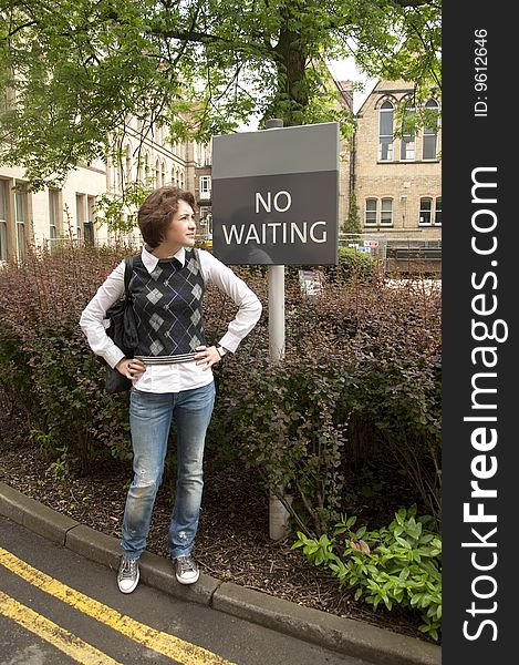 Young woman stands near the sign-post 'No waiting'