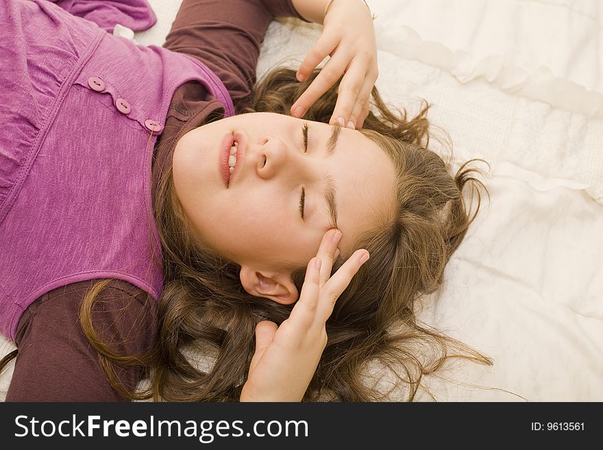 A young girl lying in bed with her eyes closed