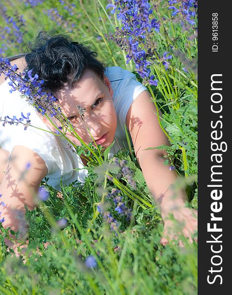 Girl in the fielg look through the wild flowers. Girl in the fielg look through the wild flowers