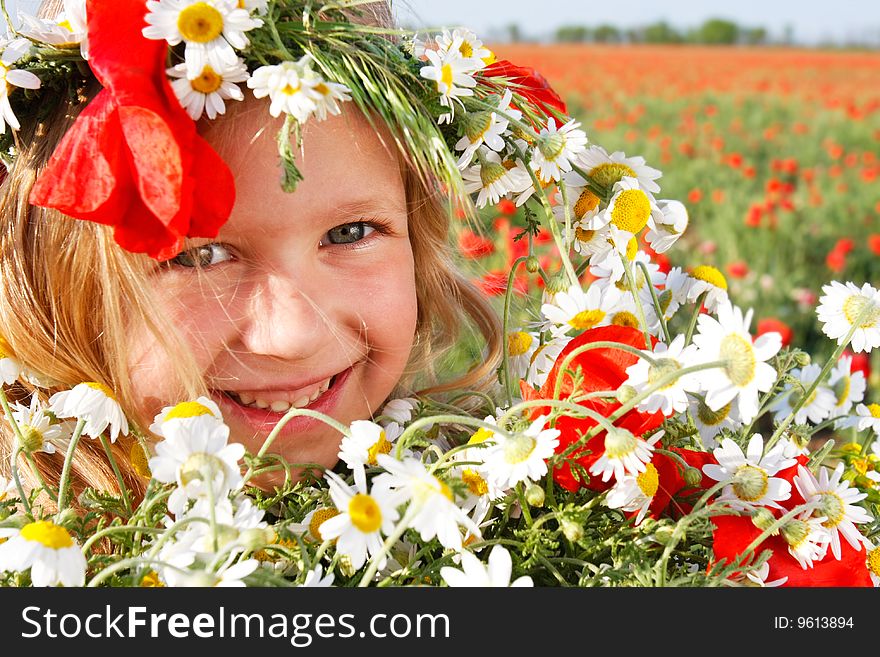 Happy girl in floral wreath on natural background