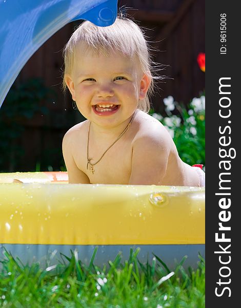 Happy little girl in yellow pool