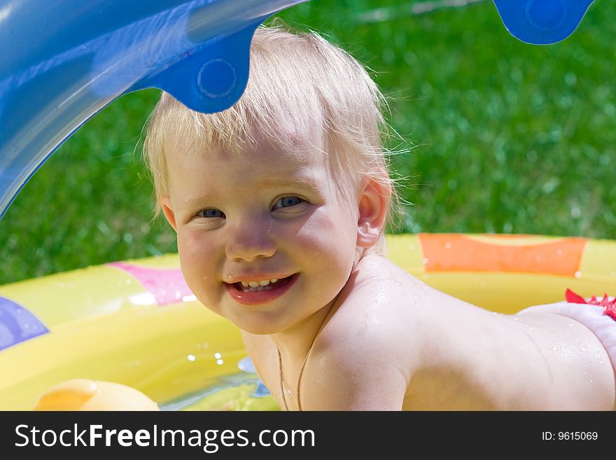 Happy little girl in yellow pool