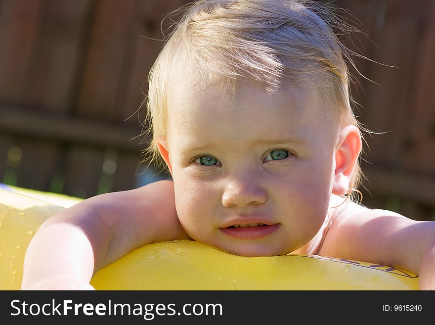 Funny little girl in yellow pool