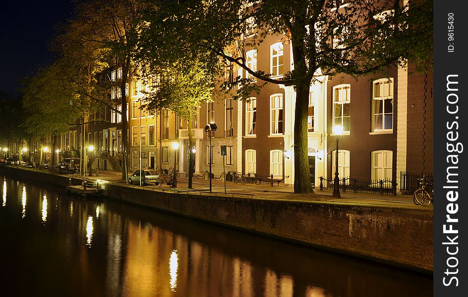 Street scene at night along a canal in Amsterdam. Street scene at night along a canal in Amsterdam