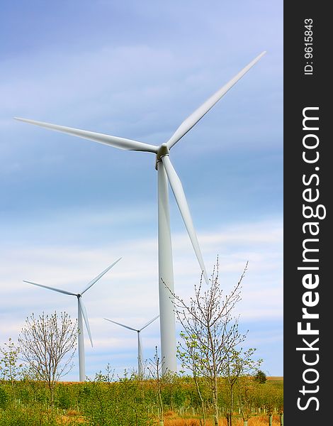 Modern windmills against blue sky, springtime