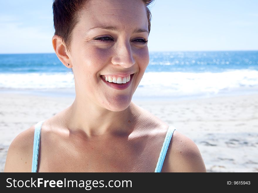 Beautiful Brunette looks at the beach with a toothy smile