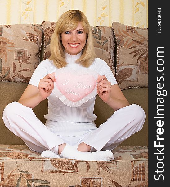 Beautiful young woman with fluffy heart pillow. Beautiful young woman with fluffy heart pillow