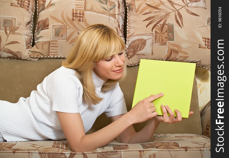 The beautiful girl sits at home with a folder for documents. The beautiful girl sits at home with a folder for documents