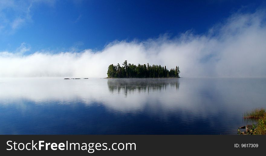 A little island with white fog background. taken at Algonquin park, Ontario, Canada