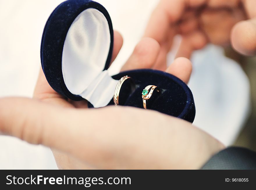 Two wedding rings in a black velvet box in hands at the groom