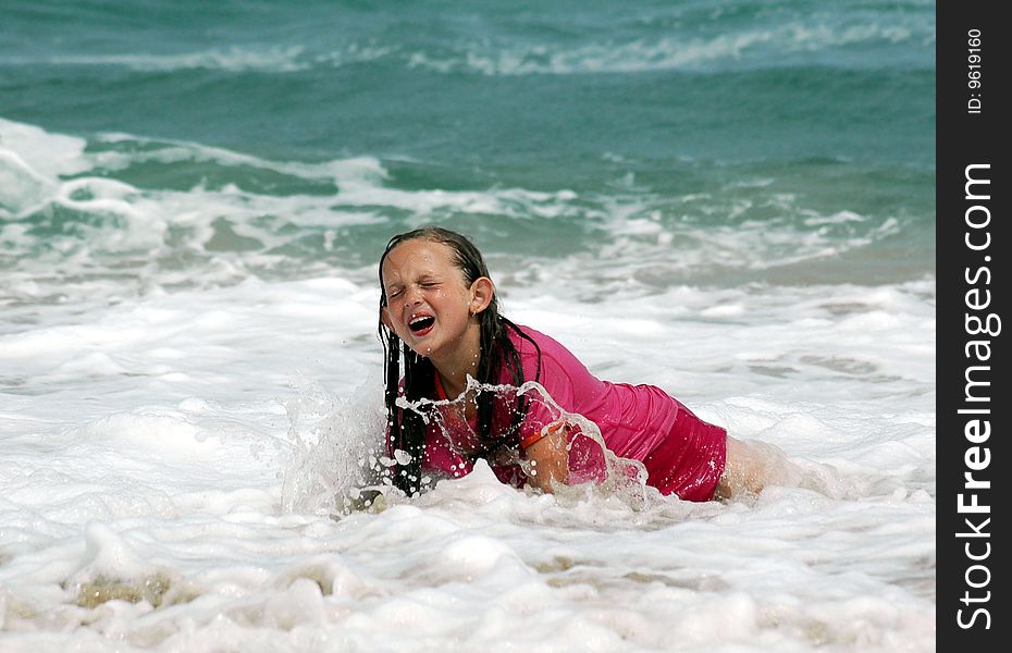 Child laughing after being dumped by a wave