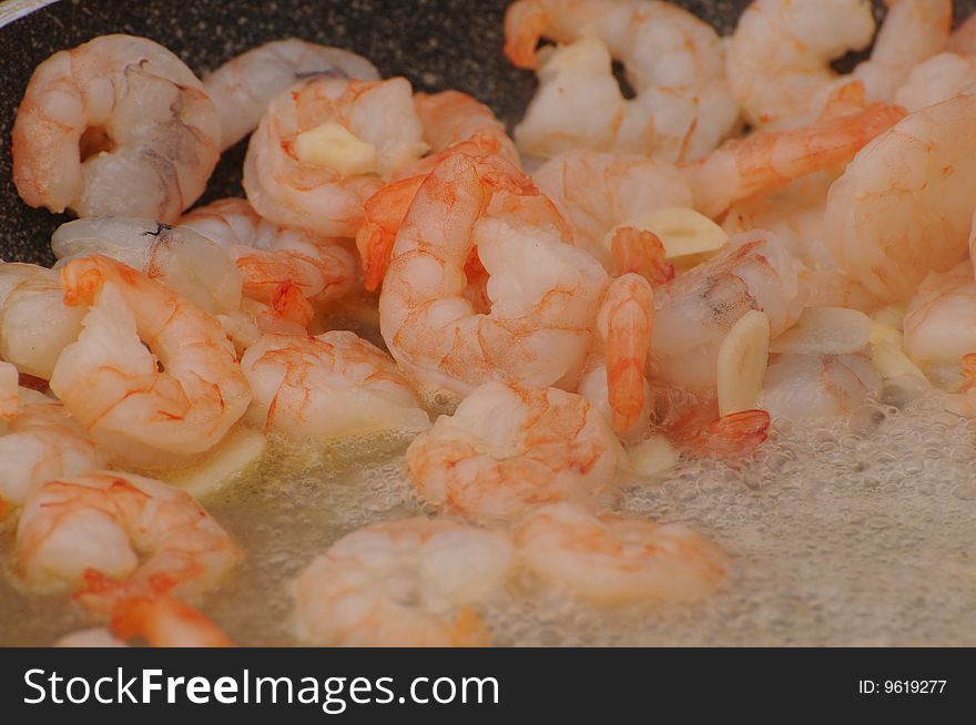 Frozen shrimps in a pan with boiling oil. Frozen shrimps in a pan with boiling oil.