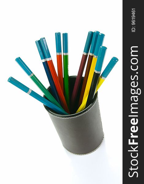 Colored Pencils in a cup holder isolated against a white background. Colored Pencils in a cup holder isolated against a white background