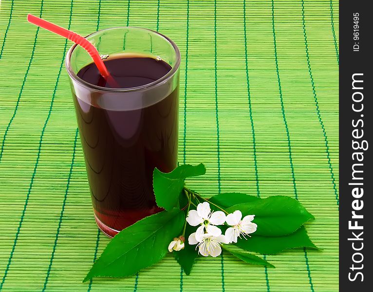 Glass of fresh cherry juice and white flowers