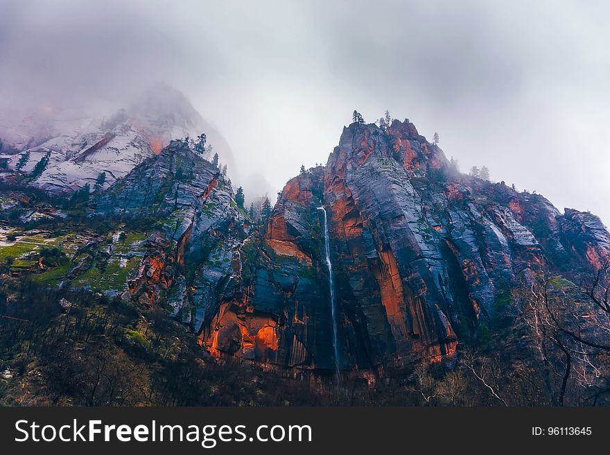 A red mountain with clouds above.