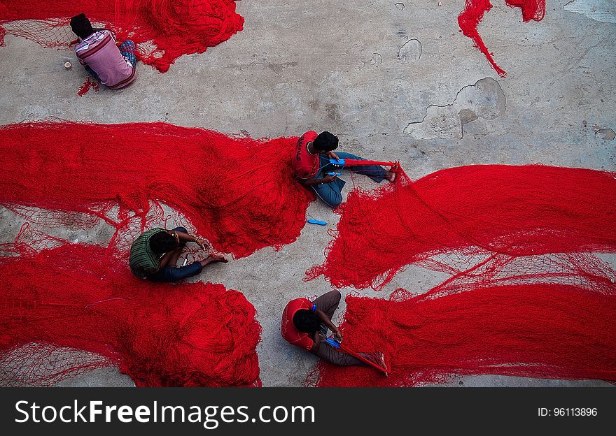 Aerial view of fishermen working on red nylon nets. Aerial view of fishermen working on red nylon nets.