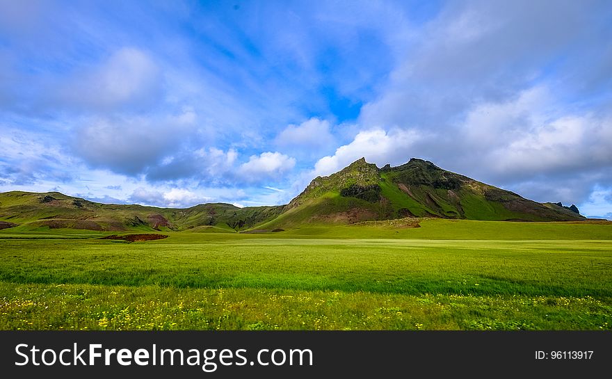 A landscape with green fields and mountains. A landscape with green fields and mountains.