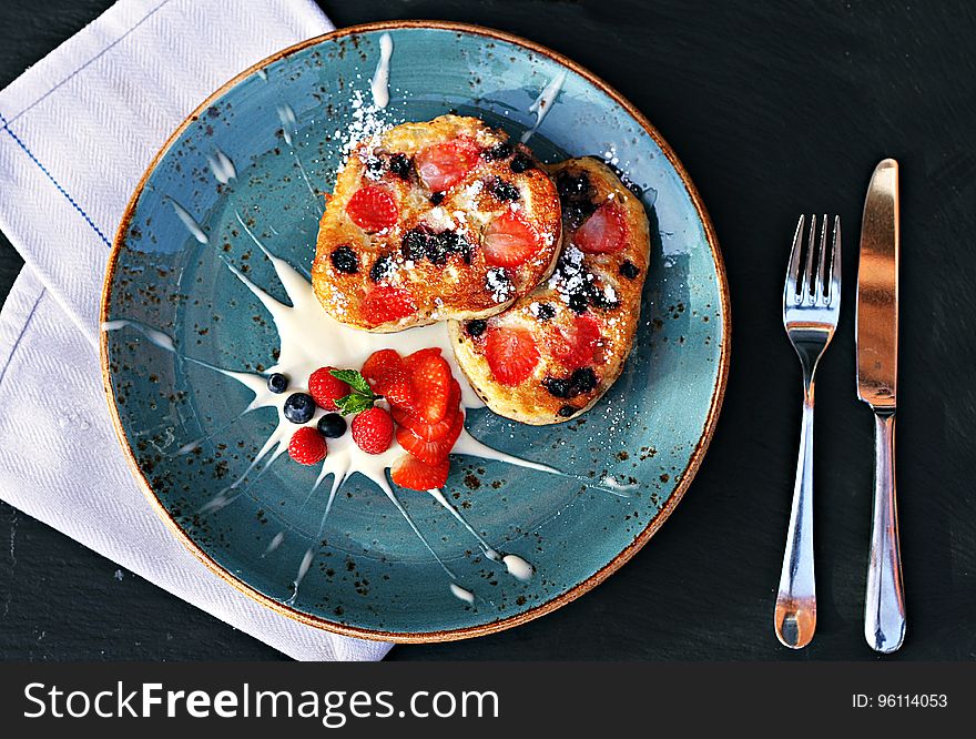 Bread slices with strawberry and blueberry topping and garnish on a plate. Bread slices with strawberry and blueberry topping and garnish on a plate.