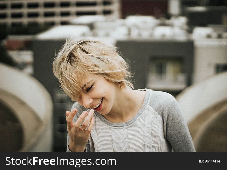 A girl with a short blonde hair laughing. A girl with a short blonde hair laughing.