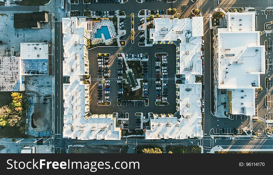 An aerial view of a block of buildings with a parking lot. An aerial view of a block of buildings with a parking lot.